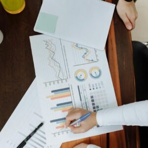 Top view of business team analyzing charts and data on paper for strategic planning.